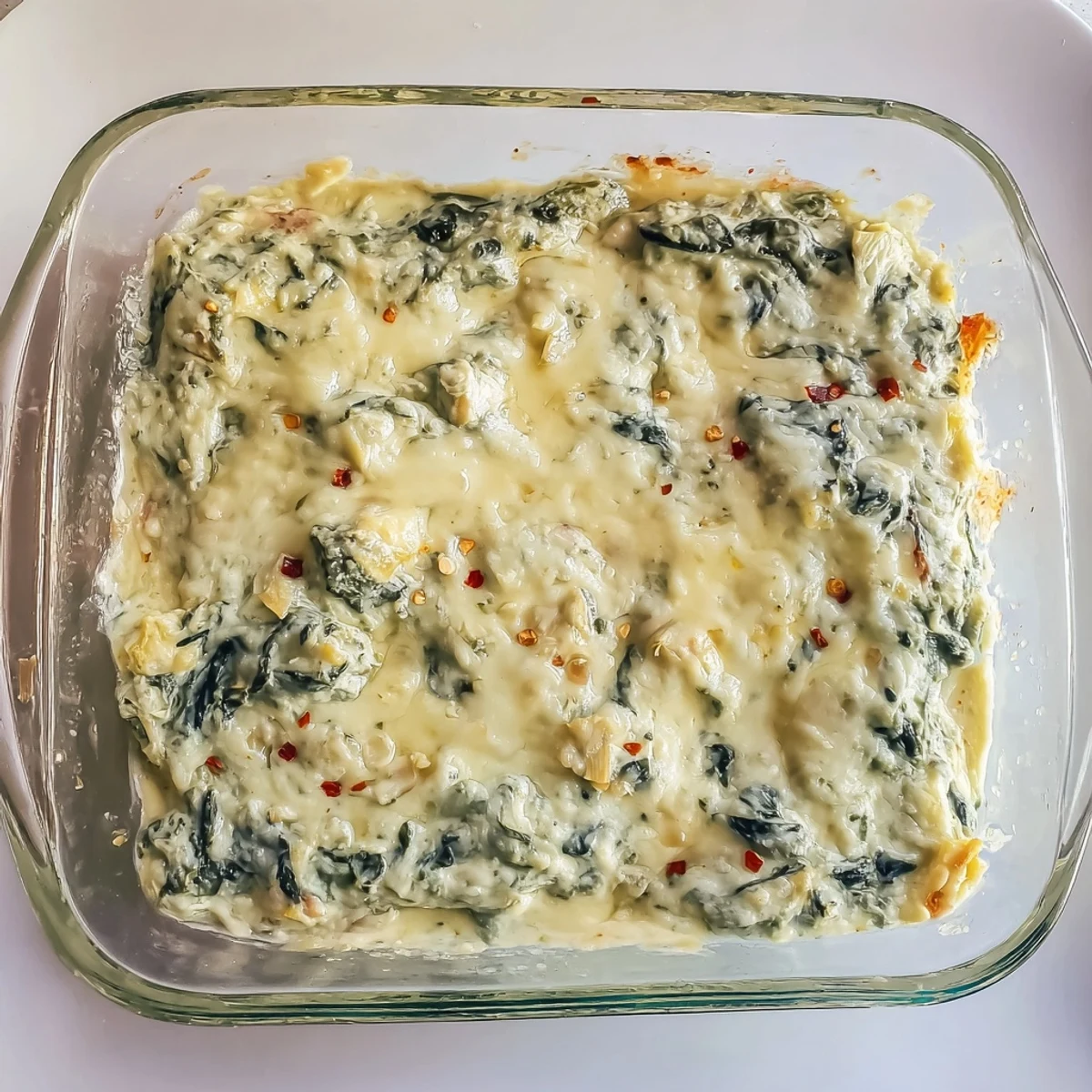 Warm spinach and artichoke dip, bubbly and golden, served with toasted baguette slices for dipping.