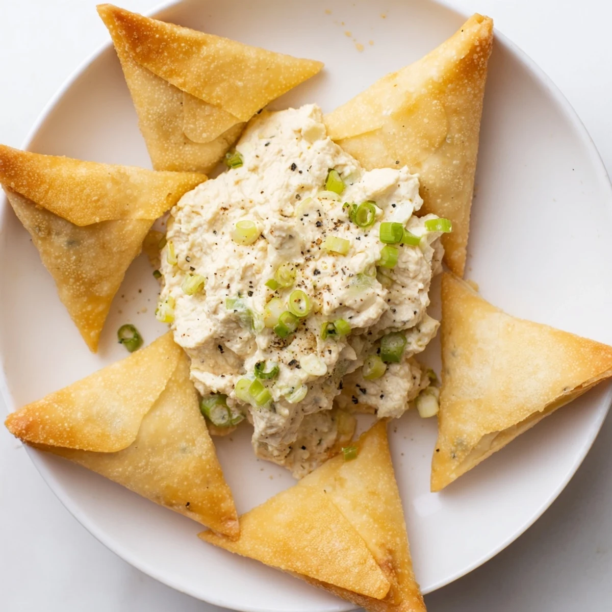 Golden, airy Air Fryer Lumpia Chips provide the perfect crunch, dipped into a rich chicken and cream cheese spread.