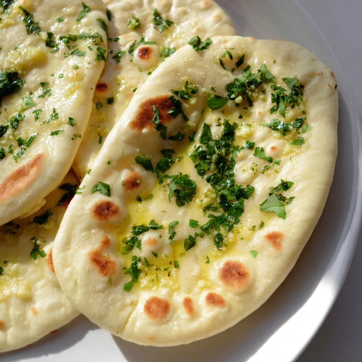 Freshly cooked garlic naan, its soft texture visible, offering a delicious aroma for dinner tonight.