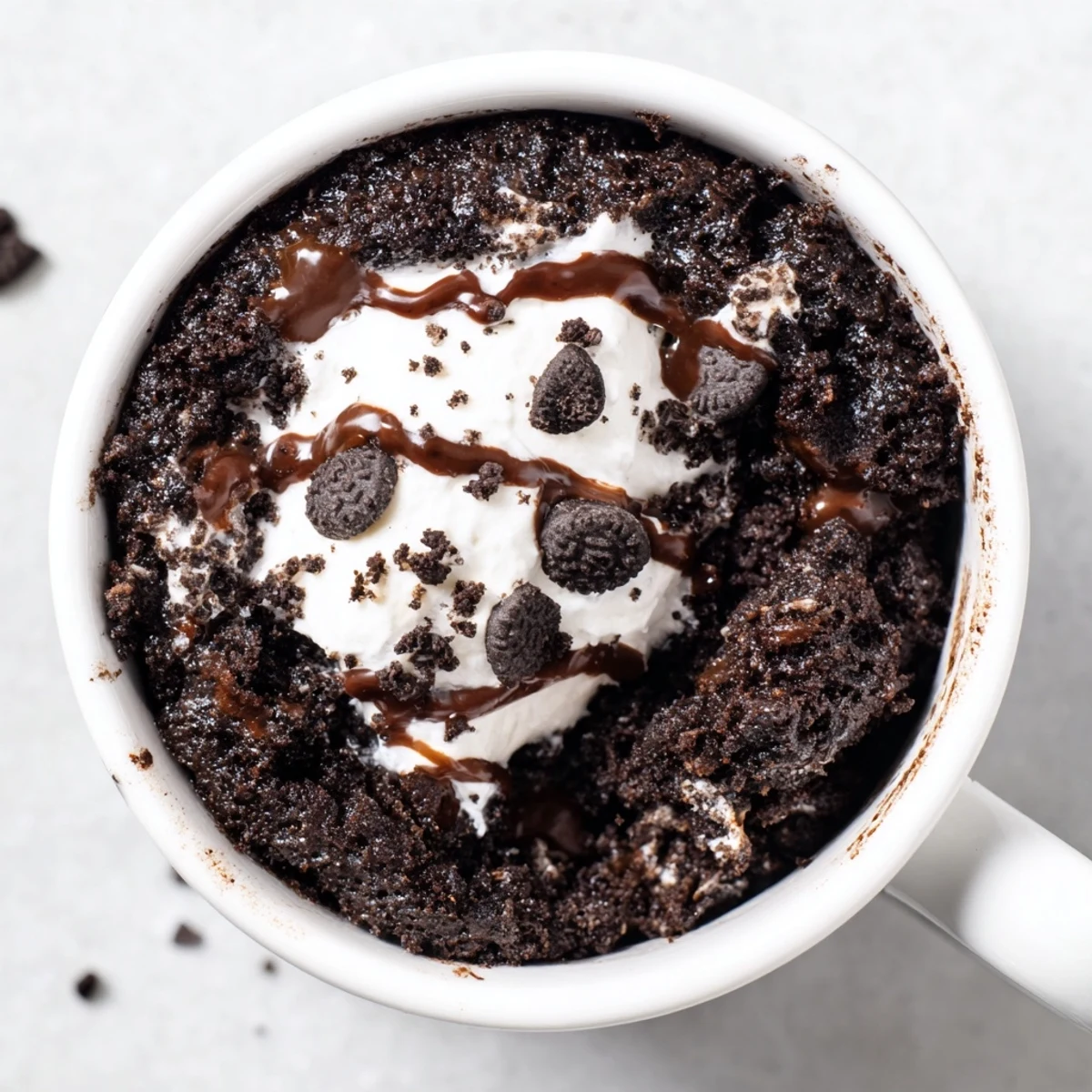A close-up of a freshly made Oreo mug cake, moist and fudgy, ready to enjoy immediately.