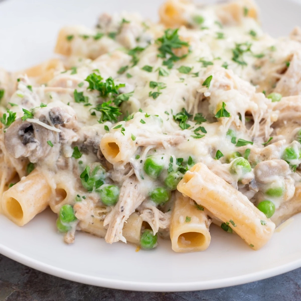 Slow Cooker Chicken Alfredo Pasta Bake: creamy, bubbling, cheesy goodness, ready for a satisfying, comforting meal.