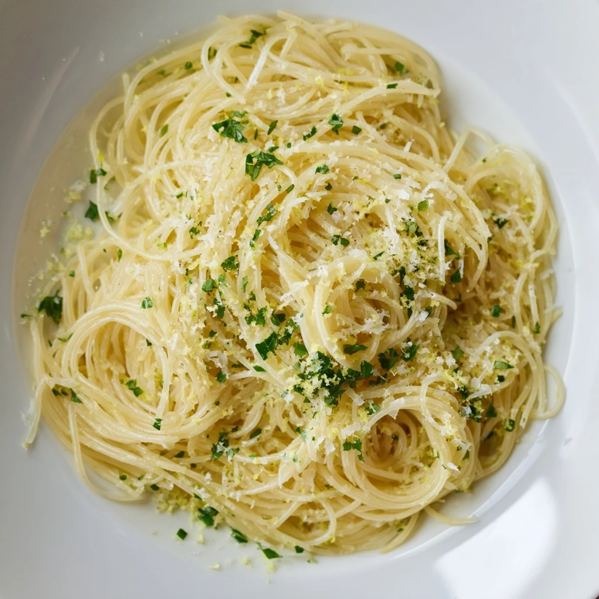 Lemon Capellini coated in a luscious sauce, garnished with fresh herbs and zesty lemon.
