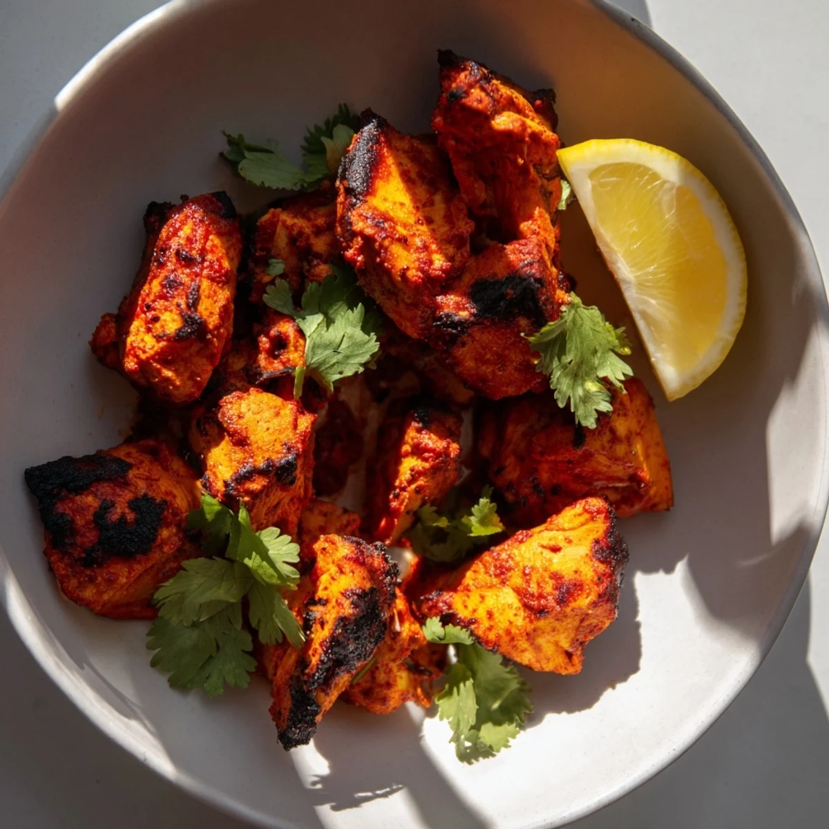 Juicy Indian Tikka Spiced Chicken, roasted to golden perfection with aromatic tandoori spices and served with fresh cilantro and lemon wedges.