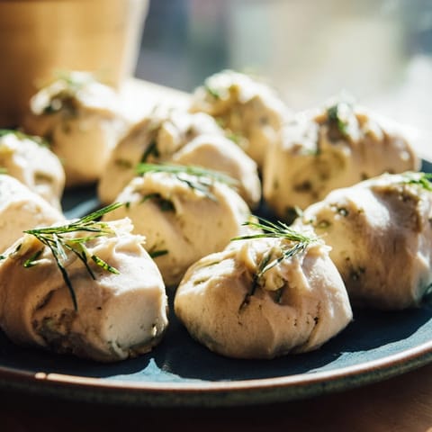 Close-up of The Stormy Sea: a gourmet, flavorful appetizer with creamy goat cheese dolloped on dark crackers.