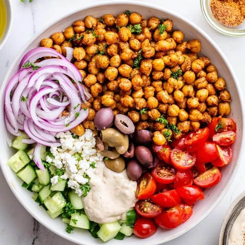Savory roasted chickpeas star in this vibrant Mediterranean Chickpea Bowl, drizzled with creamy tahini dressing.