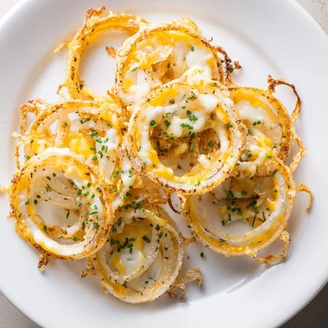 Air-fried to perfection, these Crispy Onion Cheese Chips are topped with bubbly, golden cheese and herbs.