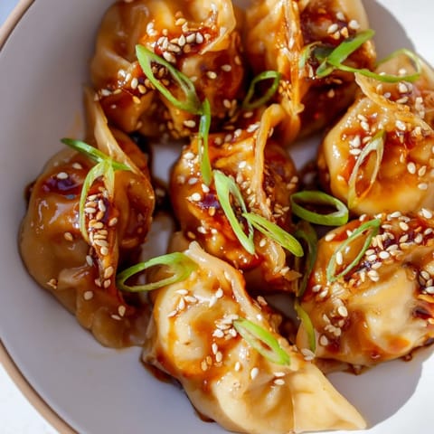 Air Fryer Frozen Dumplings with sesame seeds and green onions, offering a delicious Asian-inspired snack.