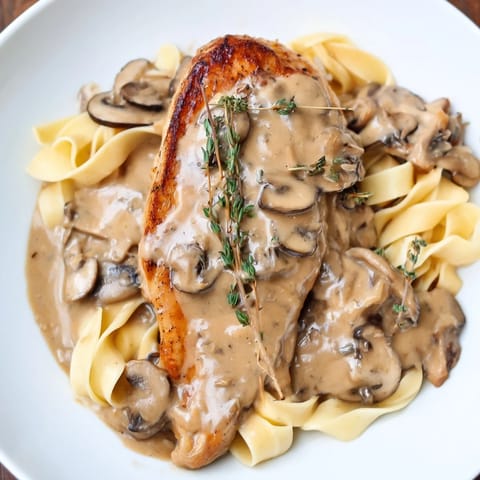 Creamy Chicken Marsala features tender chicken in a rich, savory sauce, garnished with fresh parsley and Parmesan cheese.  