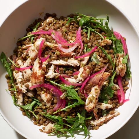 Lentil & Chicken Spring Salad served in a white bowl, featuring a zesty mustard dressing and fresh cherry tomatoes for a flavorful lunch.  