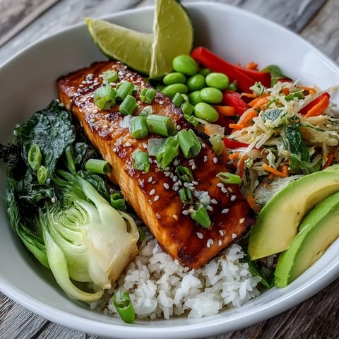 Fork-ready soy ginger salmon bowl topped with stir-fried vegetables, sesame seeds, and a lime wedge.