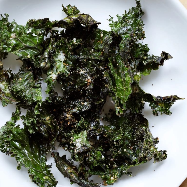 Crunchy texture of freshly baked kale chips, seasoned perfectly for a vegan, gluten-free treat.