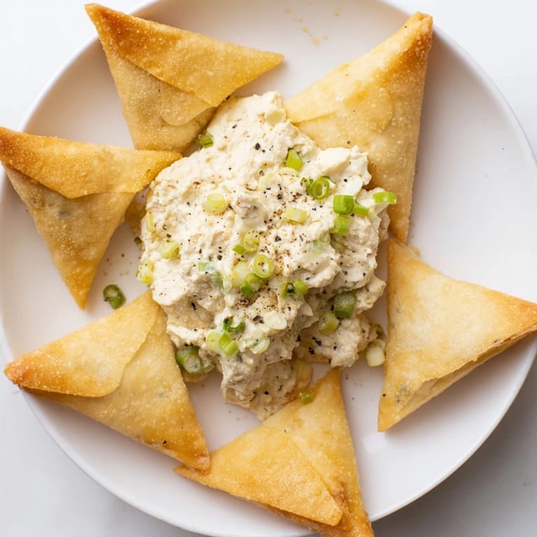 Golden, airy Air Fryer Lumpia Chips provide the perfect crunch, dipped into a rich chicken and cream cheese spread.