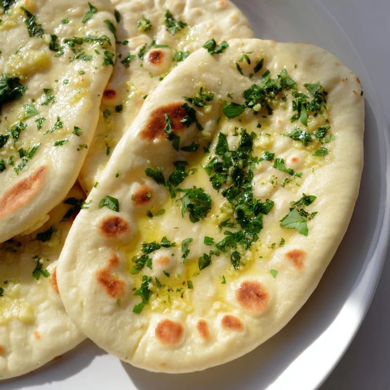 Freshly cooked garlic naan, its soft texture visible, offering a delicious aroma for dinner tonight.