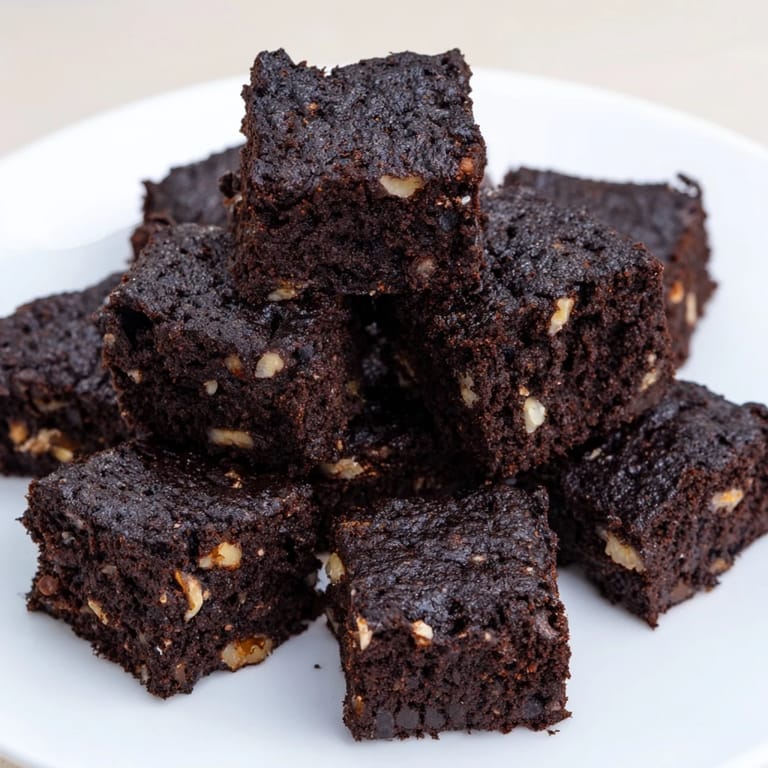 A close-up shot of rich, dark, flourless Black Bean Brownies, perfect for a gluten-free dessert.