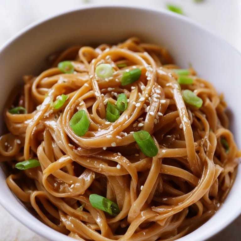 Close-up of Asian Garlic Noodle Bowl with sautéed garlic, green onions, and crunchy bean sprouts ready to serve hot.