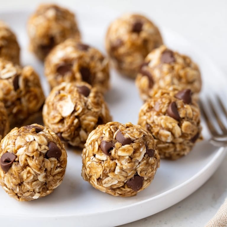Banana Chocolate Chip Energy Balls are rolled on a parchment-lined tray, perfect for an easy grab-and-go snack.