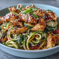 Healthy Easy Zucchini Noodle Stir Fry with Chicken in a colorful skillet, tender chicken and crisp zucchini noodles tossed with vibrant vegetables in a savory Asian sauce.